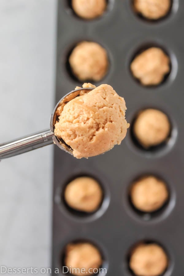 Dough being scooped into muffin tin.