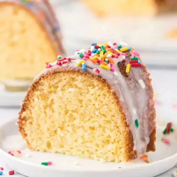 A slice of cake with sprinkles on a plate.