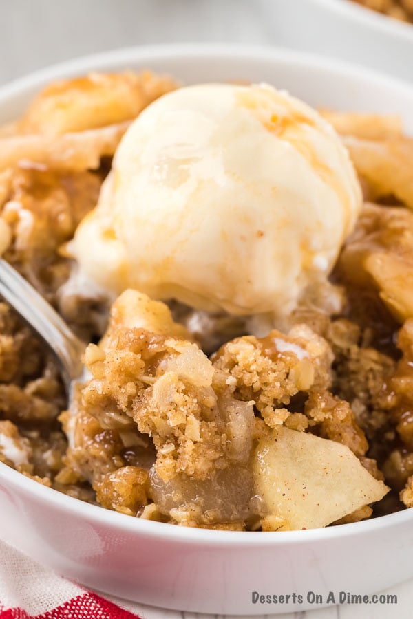 Bowl of apple crisp topped with ice cream. 