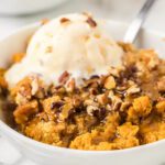 Pumpkin cobbler with pecans and ice cream.