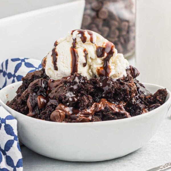 Chocolate dump cake in a bowl with ice cream.