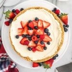 A cheesecake topped with berries and whipped cream.