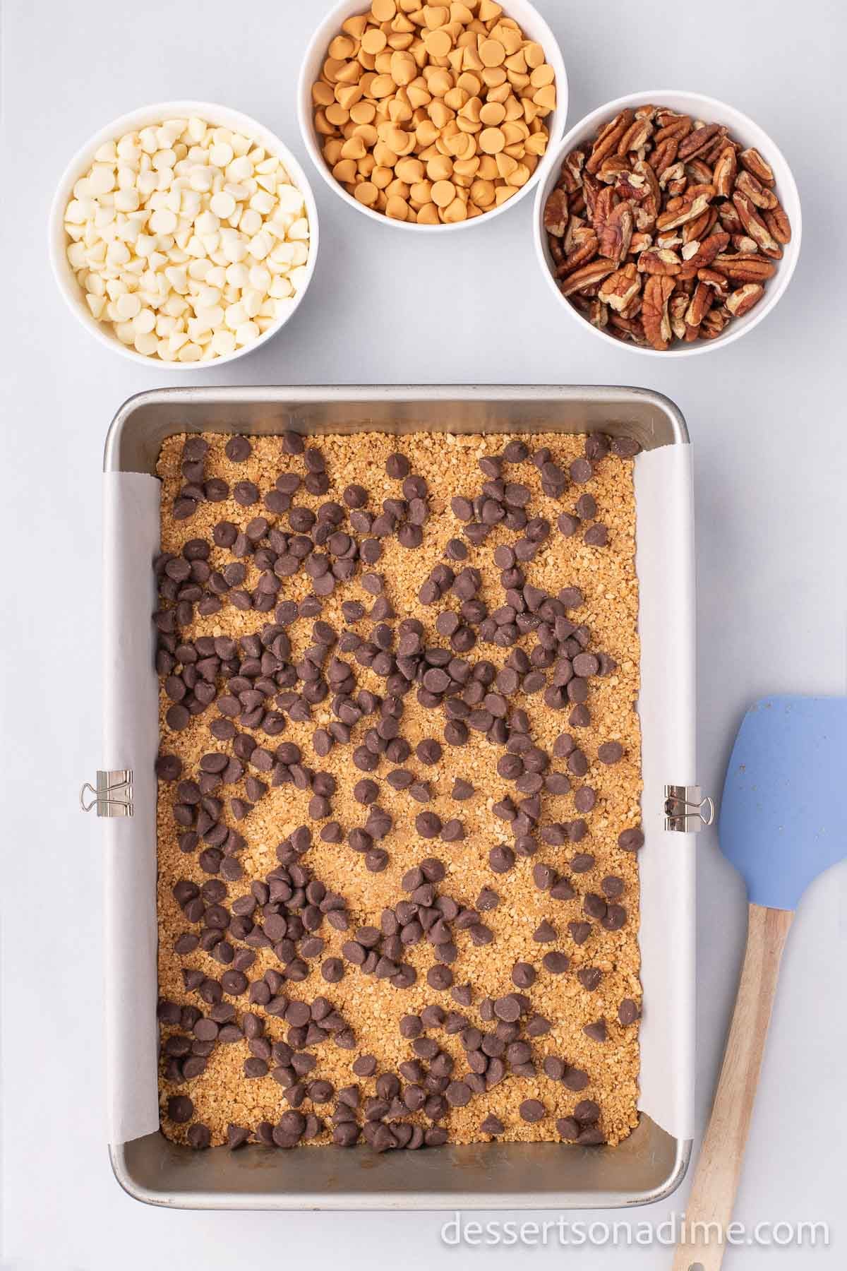 The chocolate chips spread in an even layer on top of the graham cracker crumb crust.  