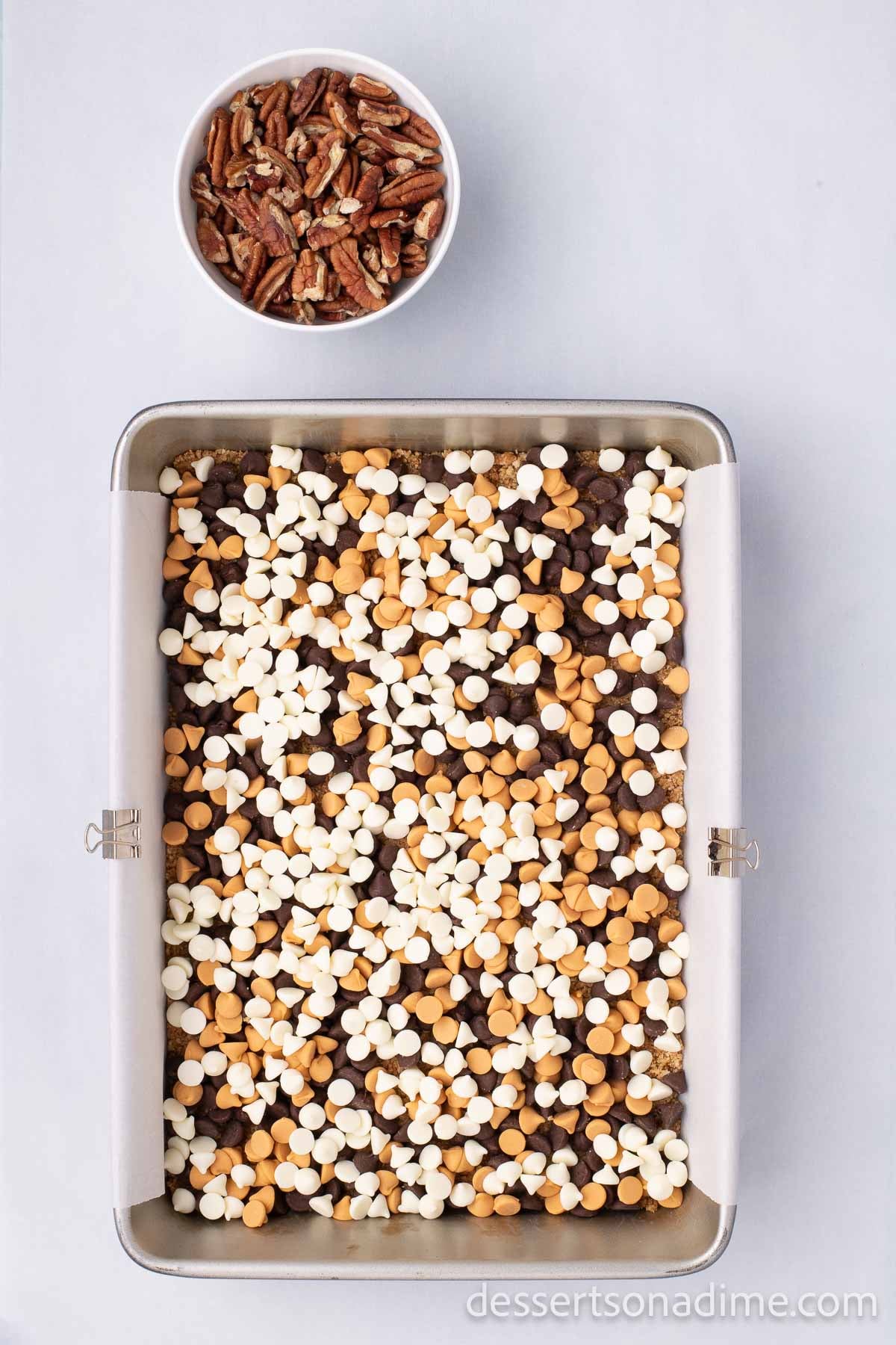 The white chocolate chips spread in an even layer on top of the graham cracker crumb crust.  