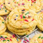 Yellow cake mix cookies with sprinkles stacked together.