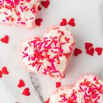 Valentine rice krispie treats in heart shapes and topped with sprinkles.