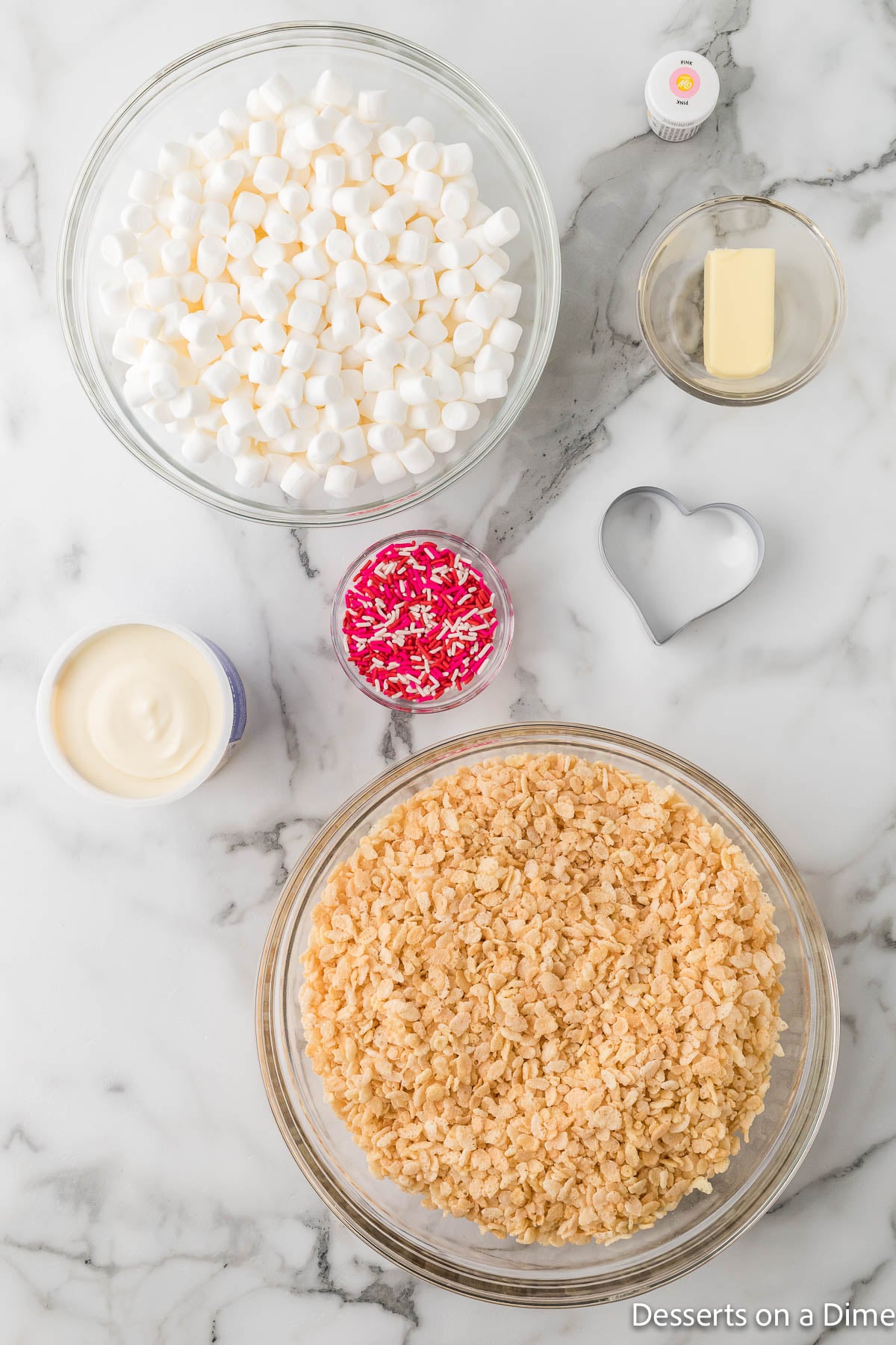 Ingredients for recipe - rice krispie cereal, mini marshmallows, red food coloring, frosting, sprinkles. 