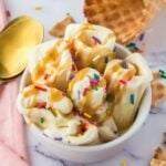 Ice cream with sprinkles and waffle cones in a bowl.