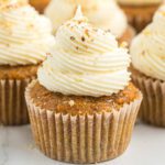 Carrot Cake cupcake topped with frosting on a plate.