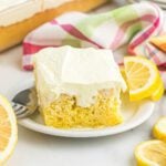 Slice of lemon poke cake on a plate.
