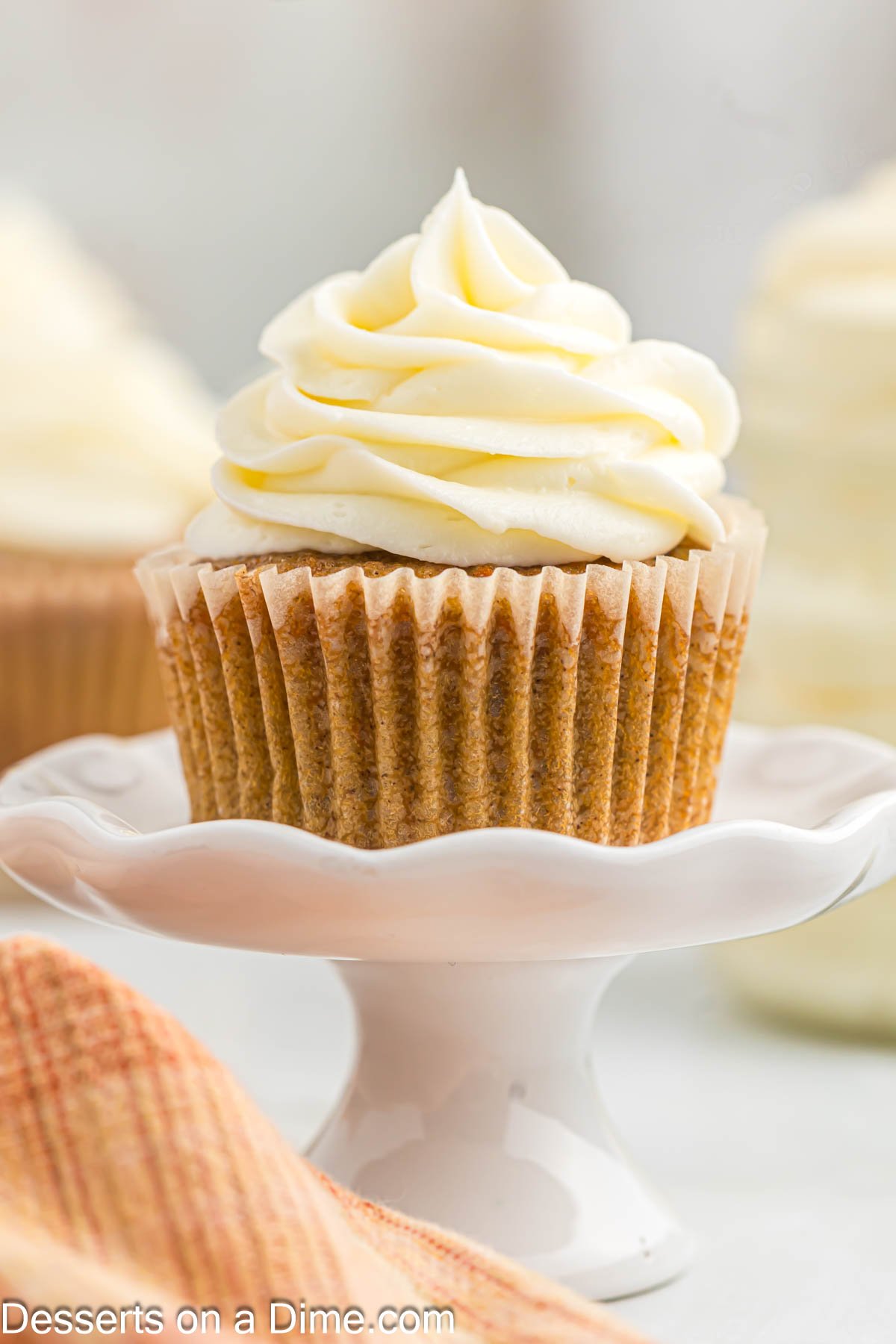 Cupcake with frosting on stand.