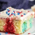 Close up image of a piece of Red White and Blue Cake on a white plate.