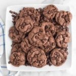 Chocolate chip cookies on a white plate.