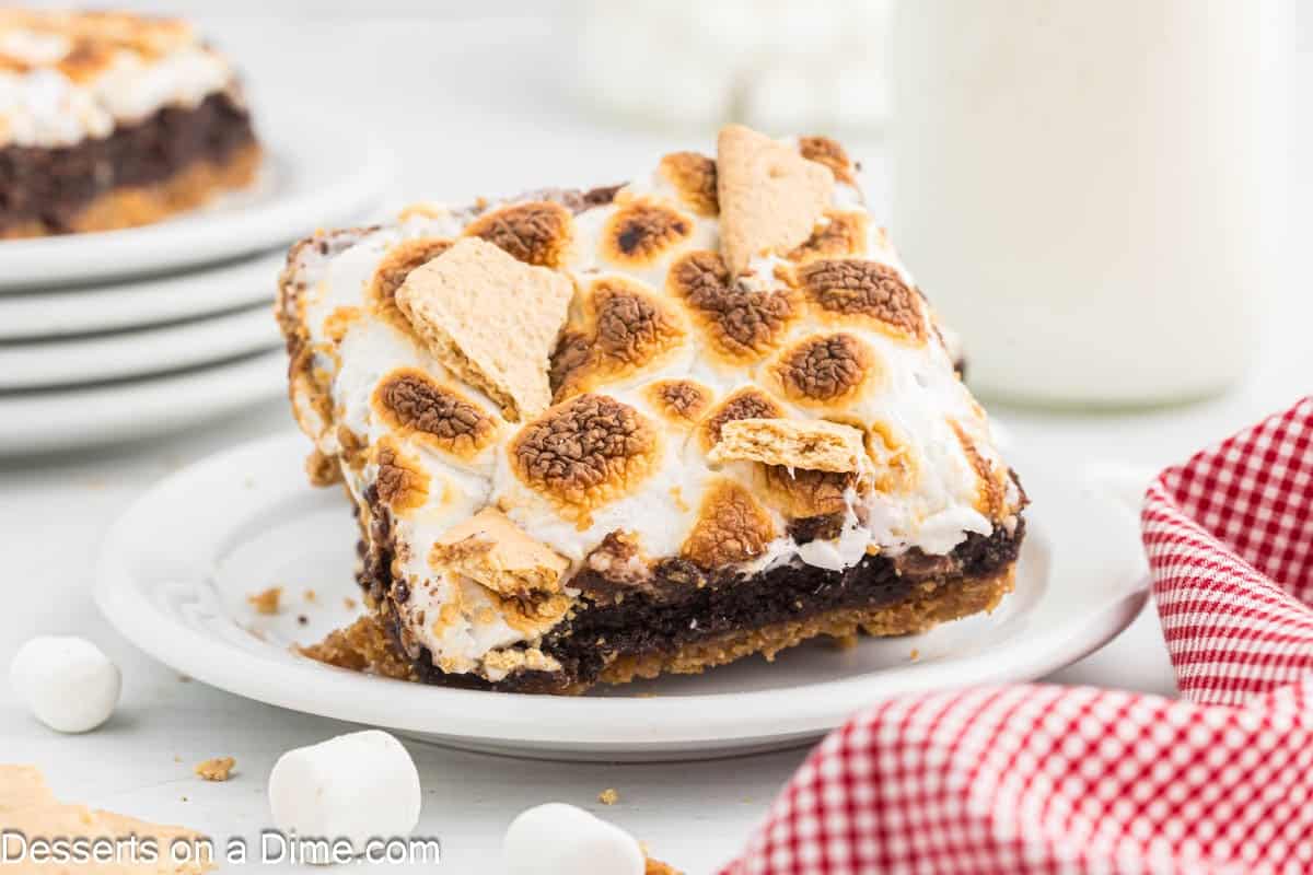S'mores brownies cut into squares on a white plate.