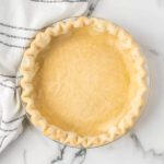 A pie crust on a marble counter.