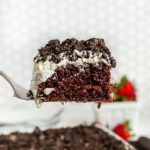 Slice of Oreo Poke Cake on a white plate.