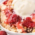 Bowl of strawberry dump cake with ice cream.