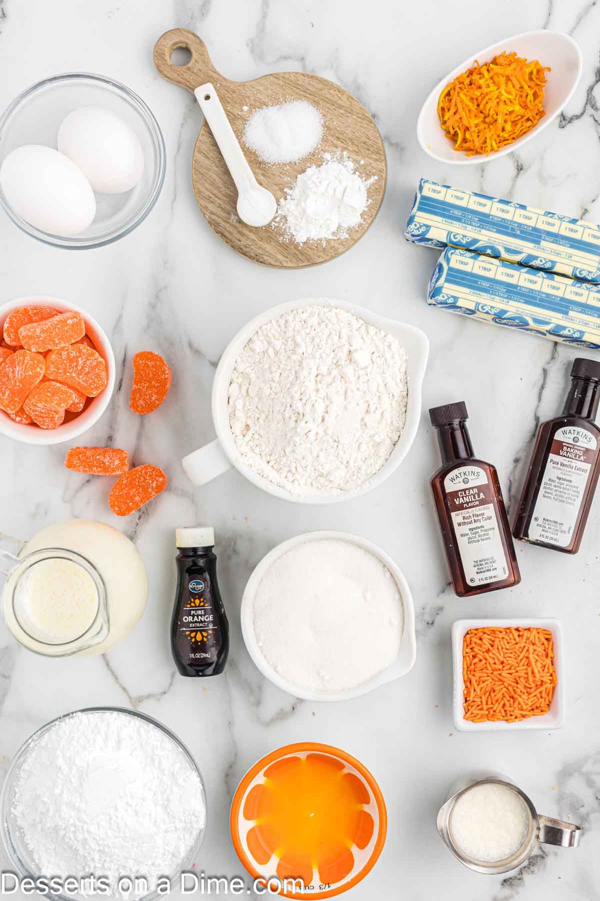 Ingredients for recipe - flour, baking powder, baking soda, white sugar, eggs, orange zest, orange juice, orange extract, buttermilk. 