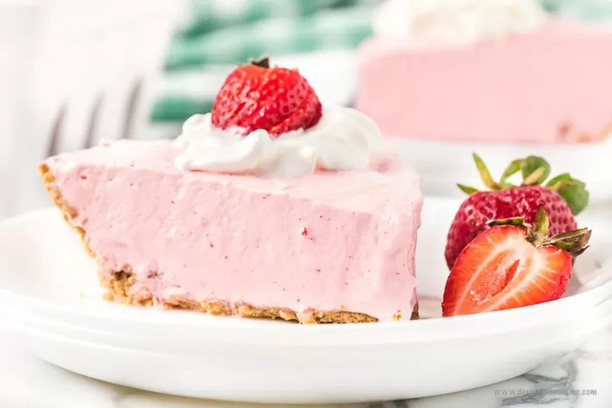 Strawberry Jello pie with a side of slice strawberries on a white plate