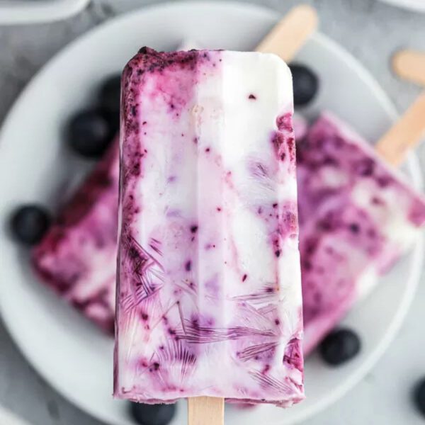 Blueberry yogurt popsicles on a white plate.
