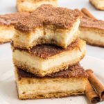 A stack of cheesecake bars on a white plate.
