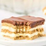 Close up image of slice of eclair cake on a white plate.