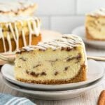 Slice of cinnamon roll cheesecake on a plate.