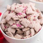 Red velvet puppy chow in a white bowl.