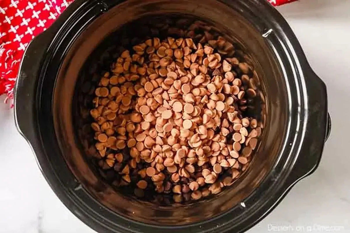 Crockpot Peanut Clusters Recipe is a simple dessert idea with only 5 ingredients. The crock pot does all the work and the results are tasty chocolate candy. Layering the chocolate chips in the slow cooker