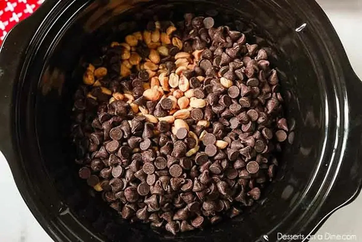Crockpot Peanut Clusters Recipe is a simple dessert idea with only 5 ingredients. The crock pot does all the work and the results are tasty chocolate candy. Layers in the chocolate chips in the slow cooker