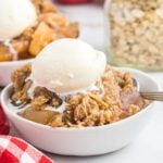 Apple crisp in a bowl with ice cream.