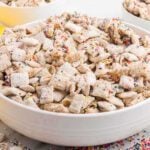 Cake batter puppy chow in a bowl.