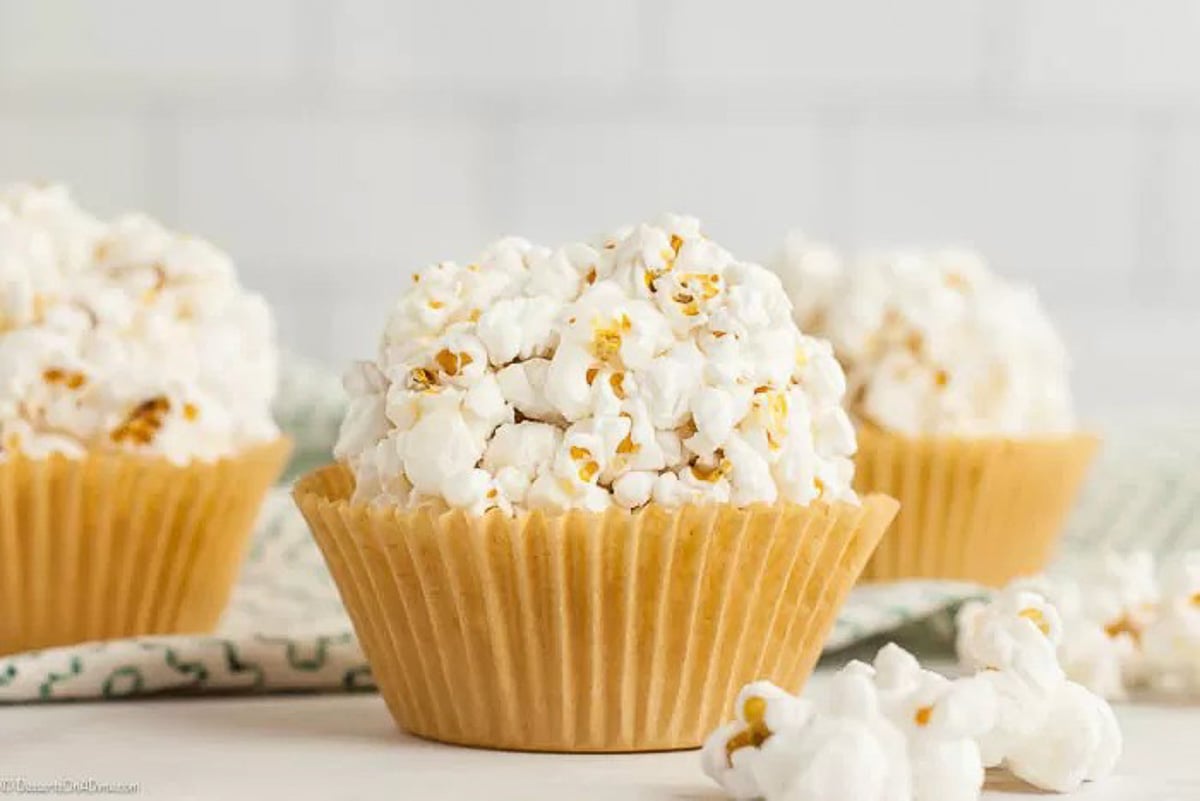 Close up of popcorn balls with popcorn scattered around it