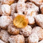 Italian donuts in a pile topped with powdered sugar.