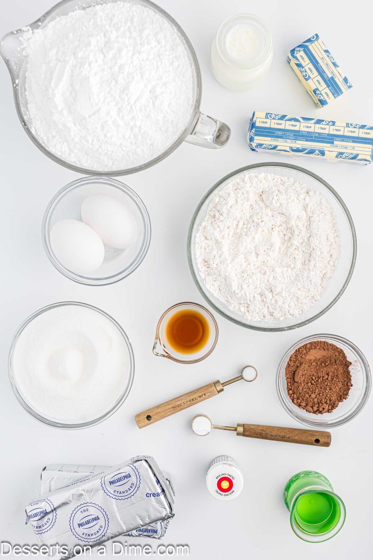 Ingredients for recipe - cake flour, cocoa powder, baking soda, eggs, vanilla, red food coloring, buttermilk, cream cheese, butter, powdered sugar. 