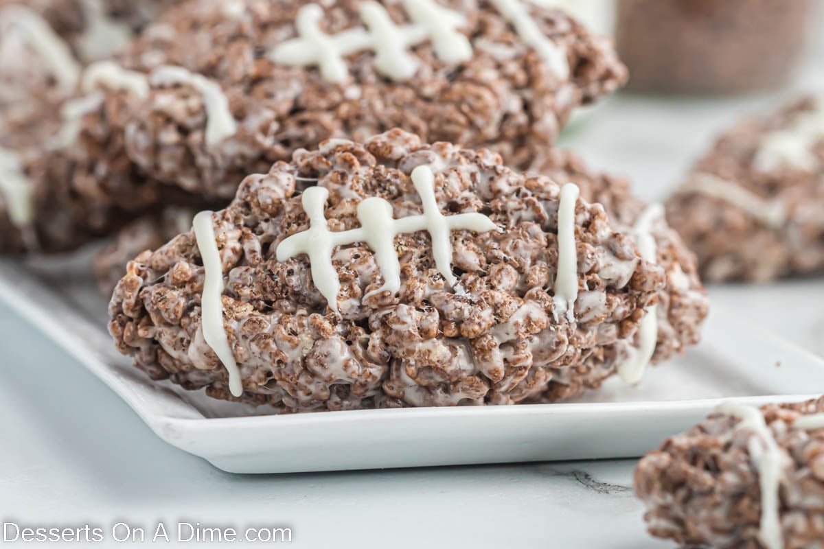Football rice krispie treats on a white plate.