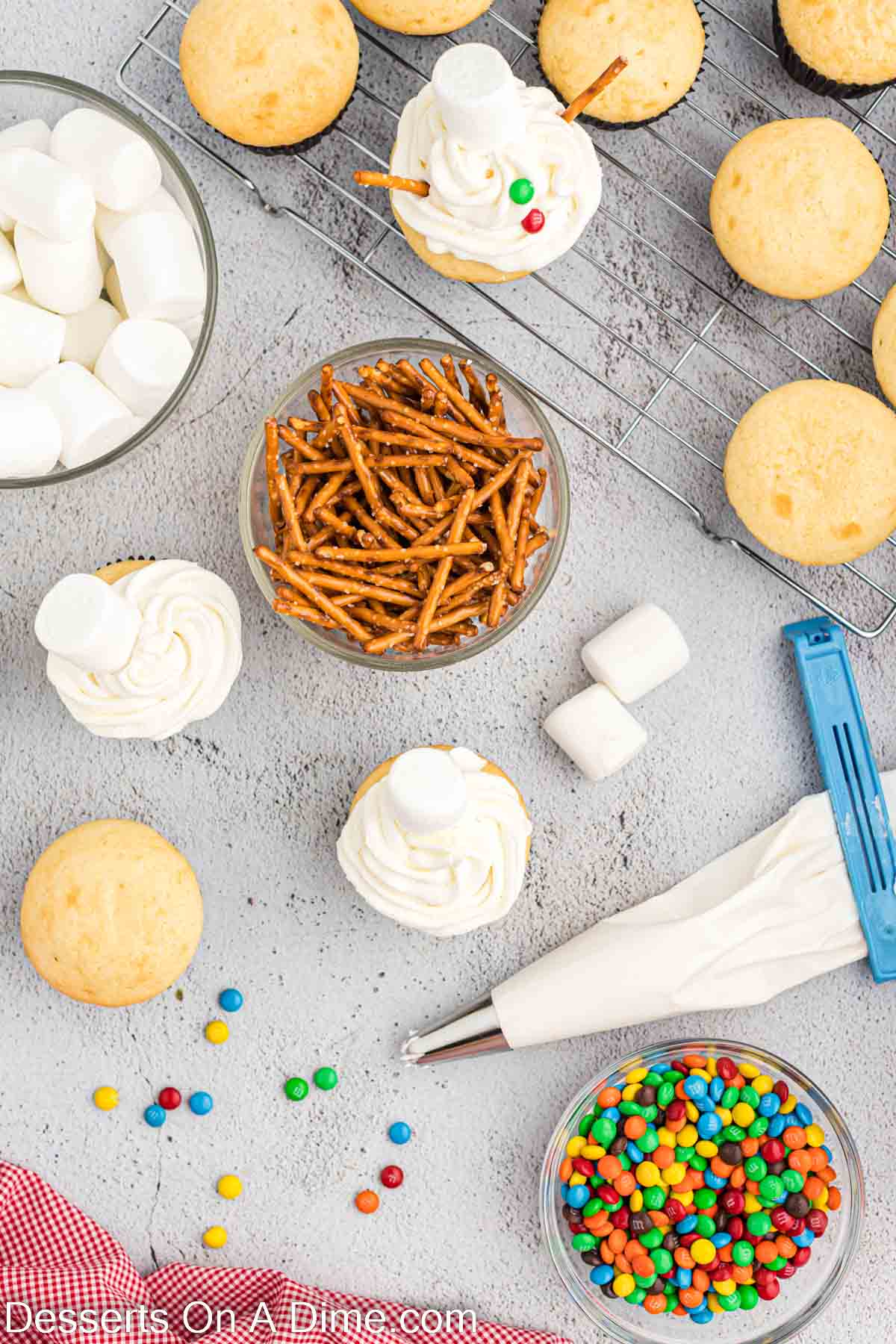 Pretzels in a bowl and cupcakes being decorated. 