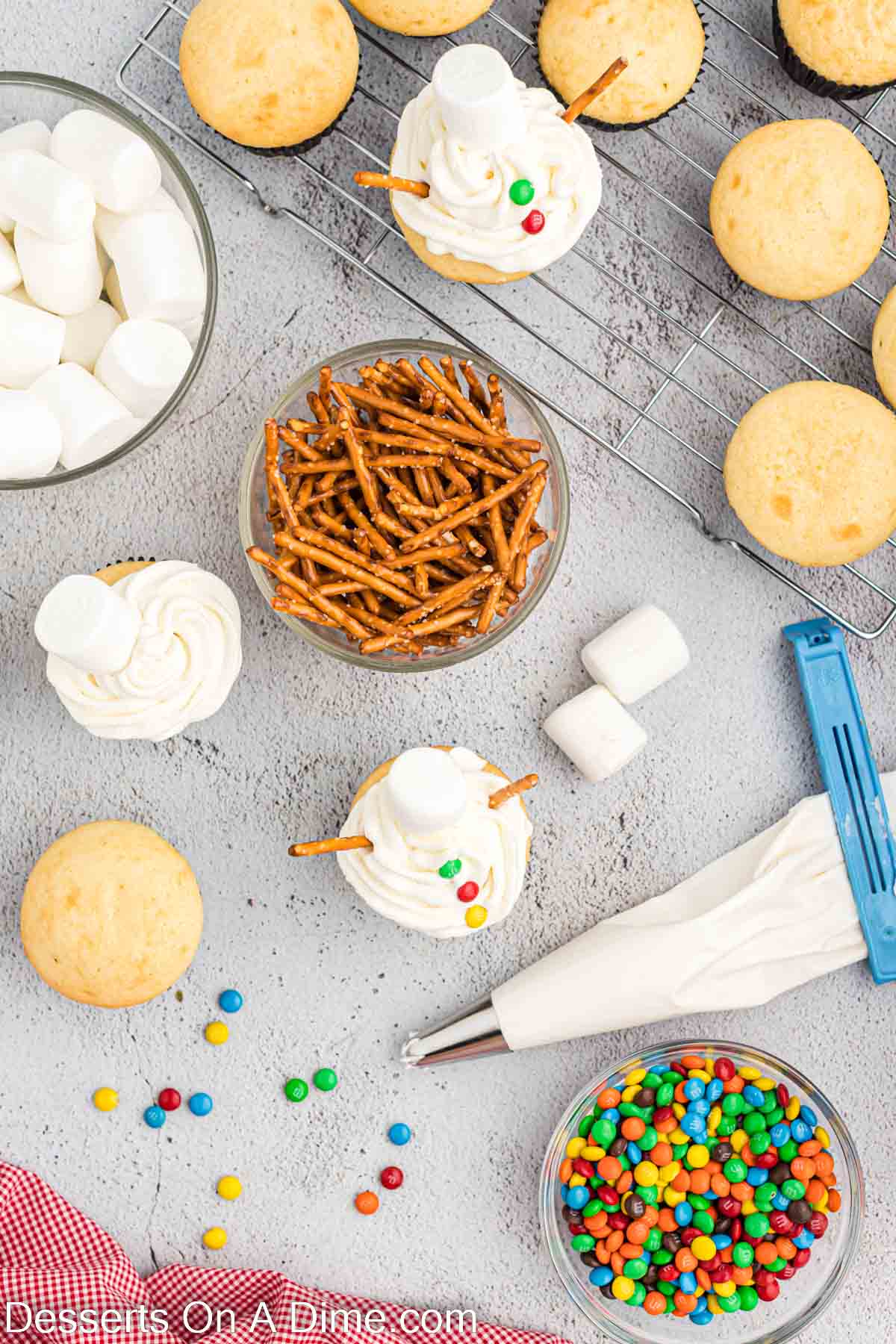 Arms being added to each cupcake and button candy. 