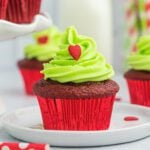 Grinch cupcake on a white plate.