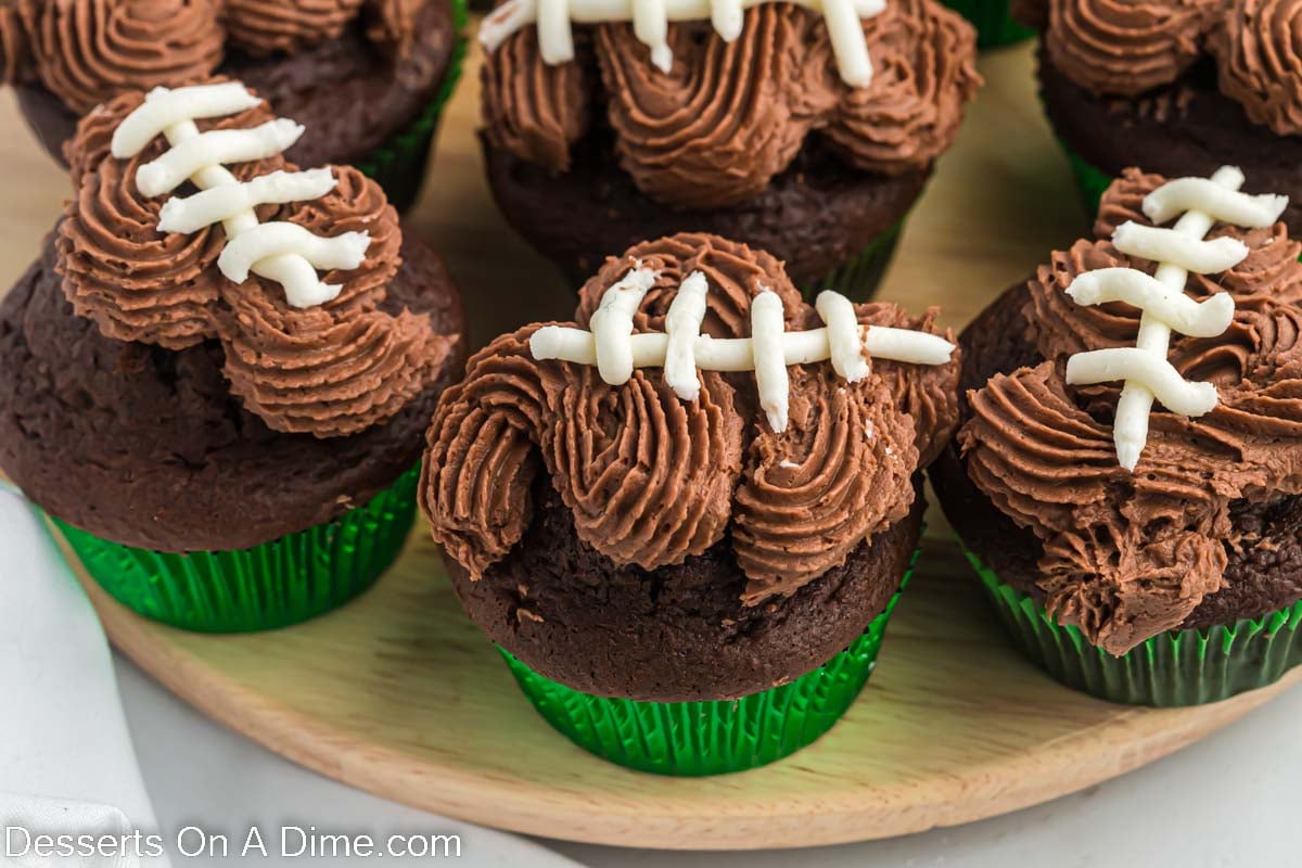 Football cupcakes on a wooden platter.