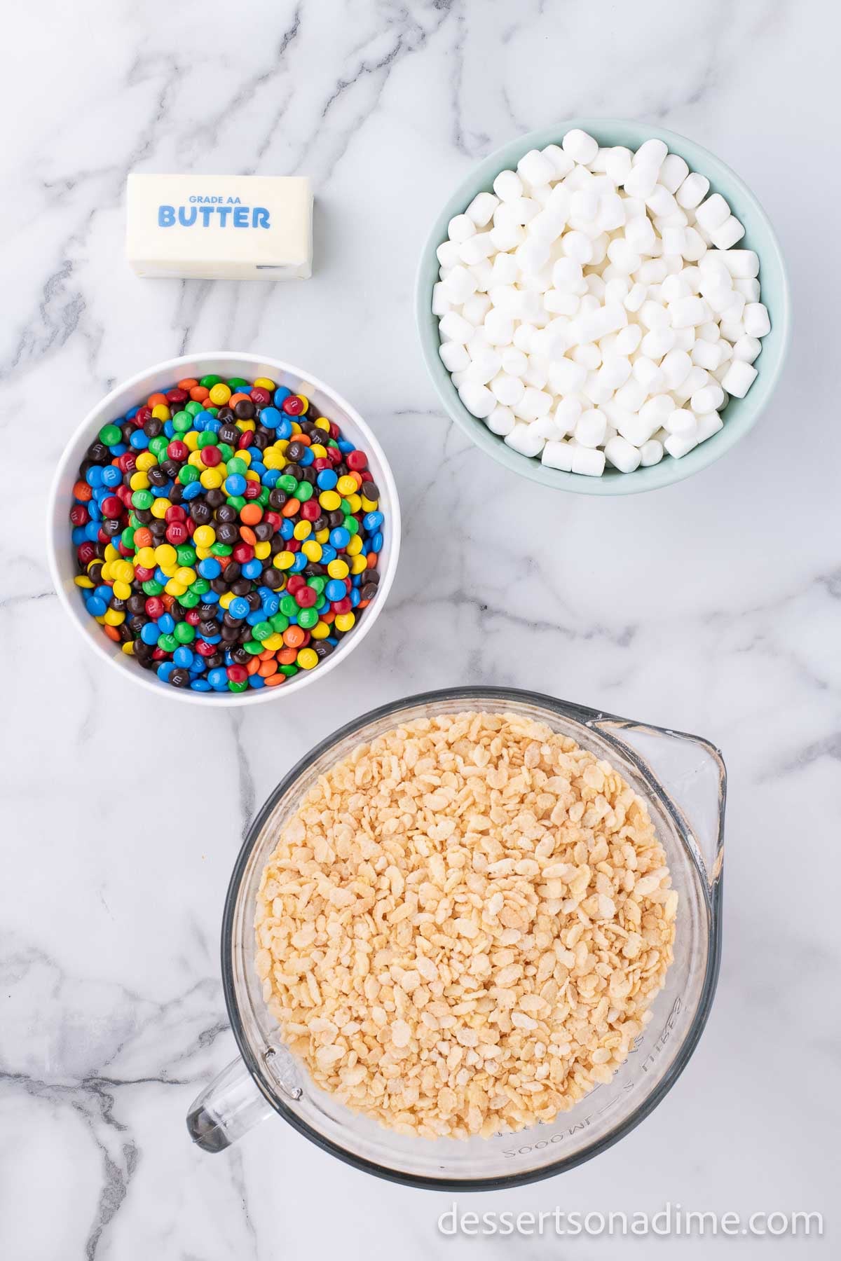 Ingredients for rice krispy treats - rice cereal, salted butter, marshmallows and mini M&Ms. 