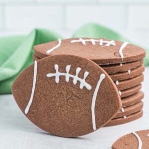Football cookies with white icing on top.