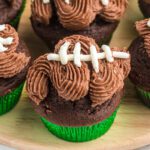 Chocolate cupcakes with football decorations on a wooden tray