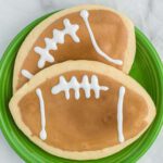 Football sugar cookies on a green platter.