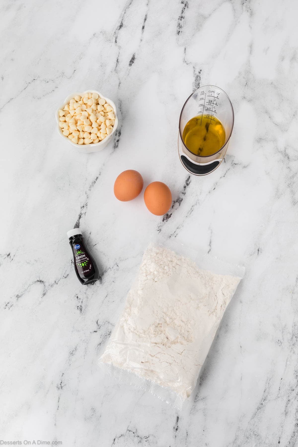 Ingredients for recipe - white cake mix, green food coloring, eggs, vegetable oil, white chocolate chips. 