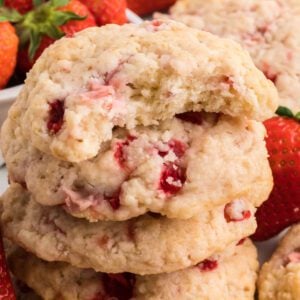 Strawberry shortcake cookies are stacked on top of each other.