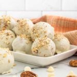 White chocolate pecan balls on a white plate.