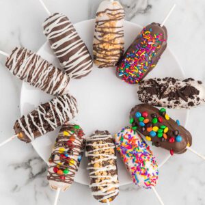 Chocolate covered twinkies on a white plate.