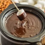 Chocolate fondue in a pot with a marshmallow.