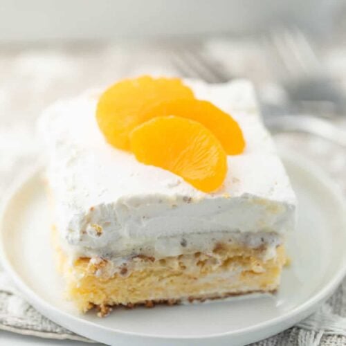 Slice of Mandarin Orange Cake on a white plate.
